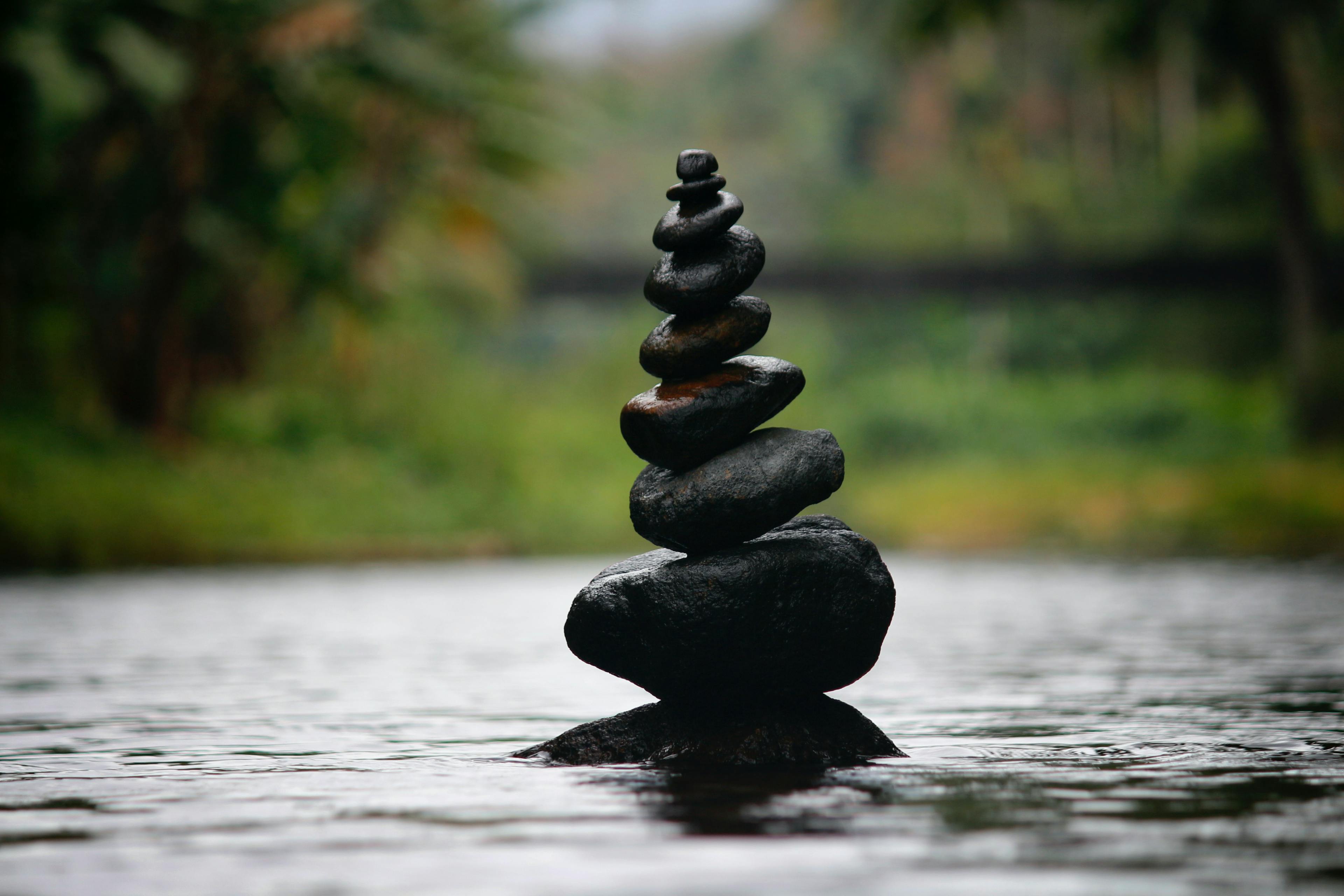 Balanced black Zen stones in water